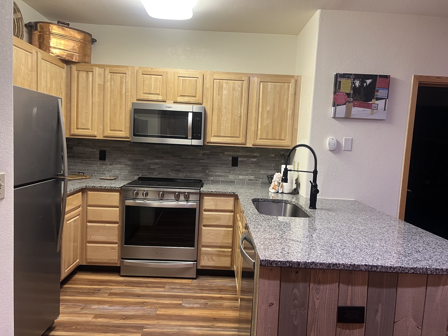 Your fully equipped kitchen features stainless steel appliances, granite countertops, and warm wood cabinetry—everything you need to prepare meals during your stay.