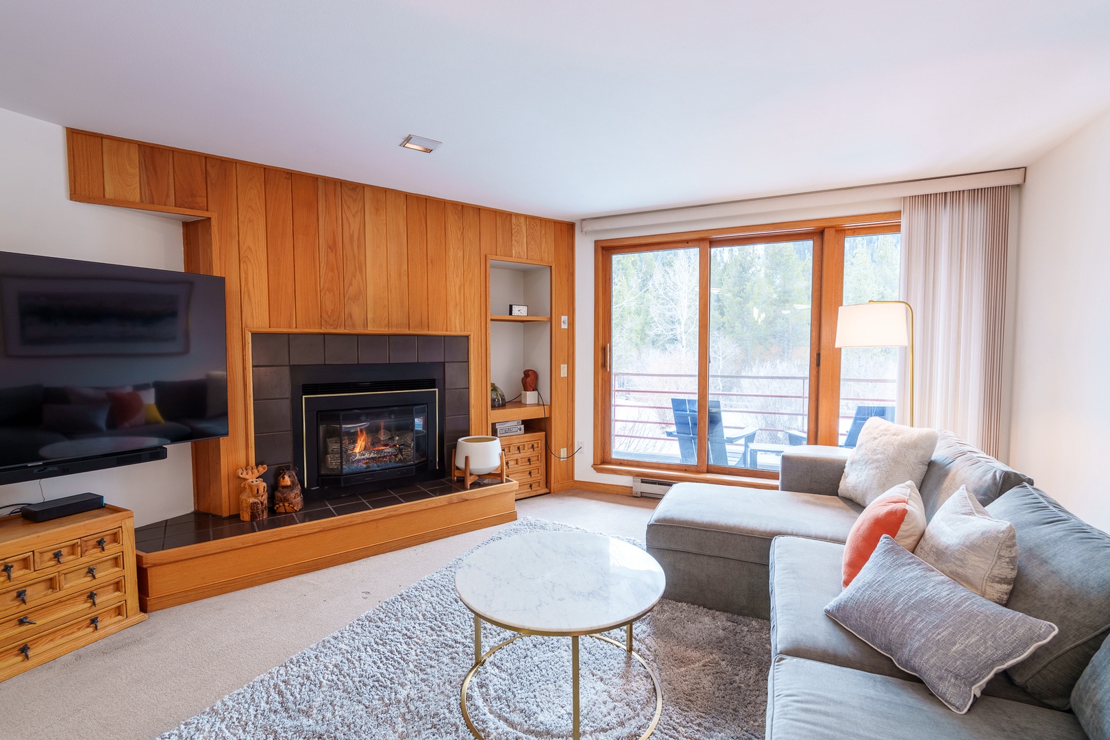Cozy up by your crackling fireplace while enjoying mountain views from your private balcony in this warm, wood-accented living space.