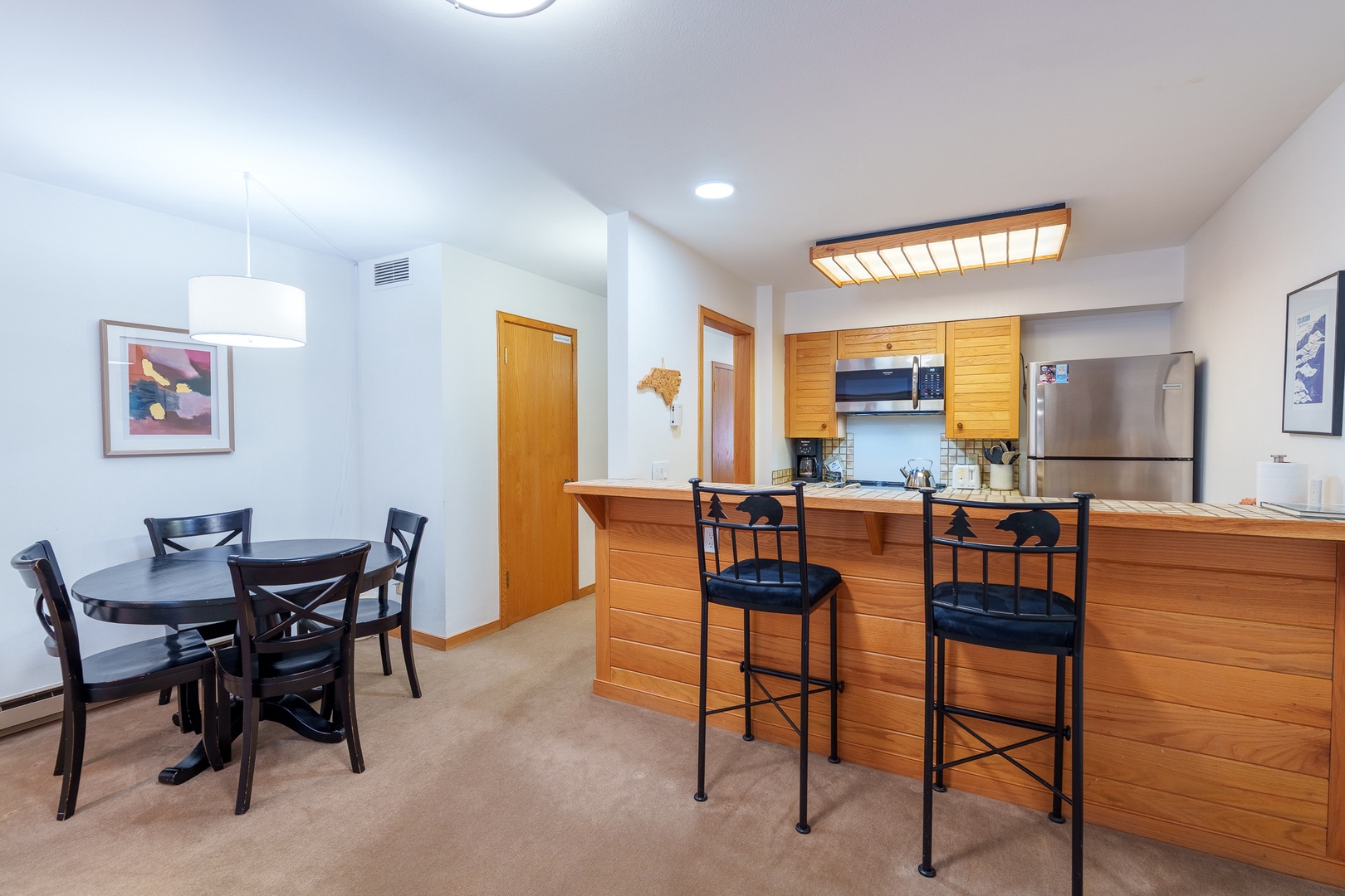 Your open-concept kitchen and dining area features warm wood cabinetry, stainless steel appliances, and a breakfast bar where you can enjoy morning coffee.