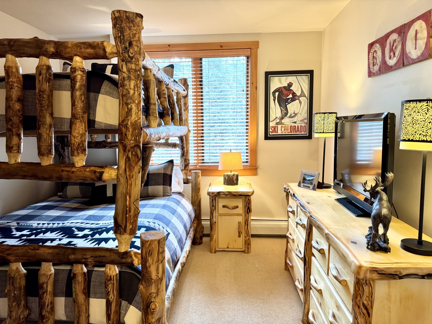 Cozy mountain-style bedroom with custom log bunk beds and rustic charm, perfect for families or groups seeking that authentic lodge experience.