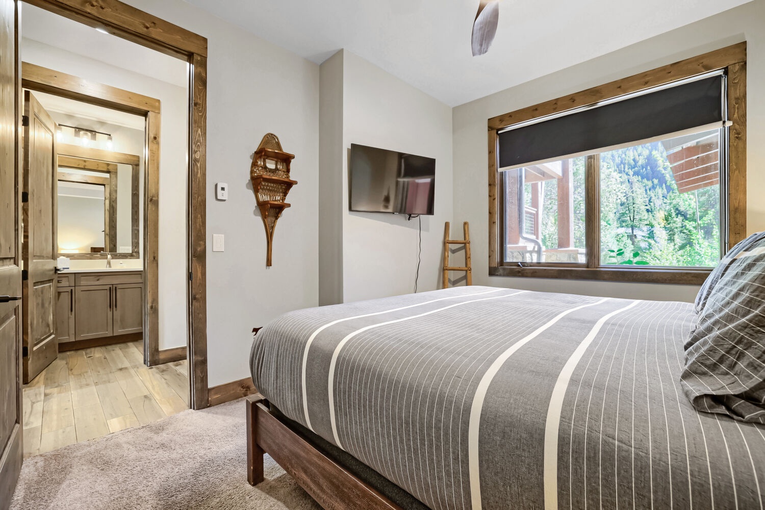 Drift off to sleep in your cozy bedroom framed by warm wood accents and crisp mountain air. The forest views through your window invite peaceful mornings, while the ensuite bath adds your own private comfort.