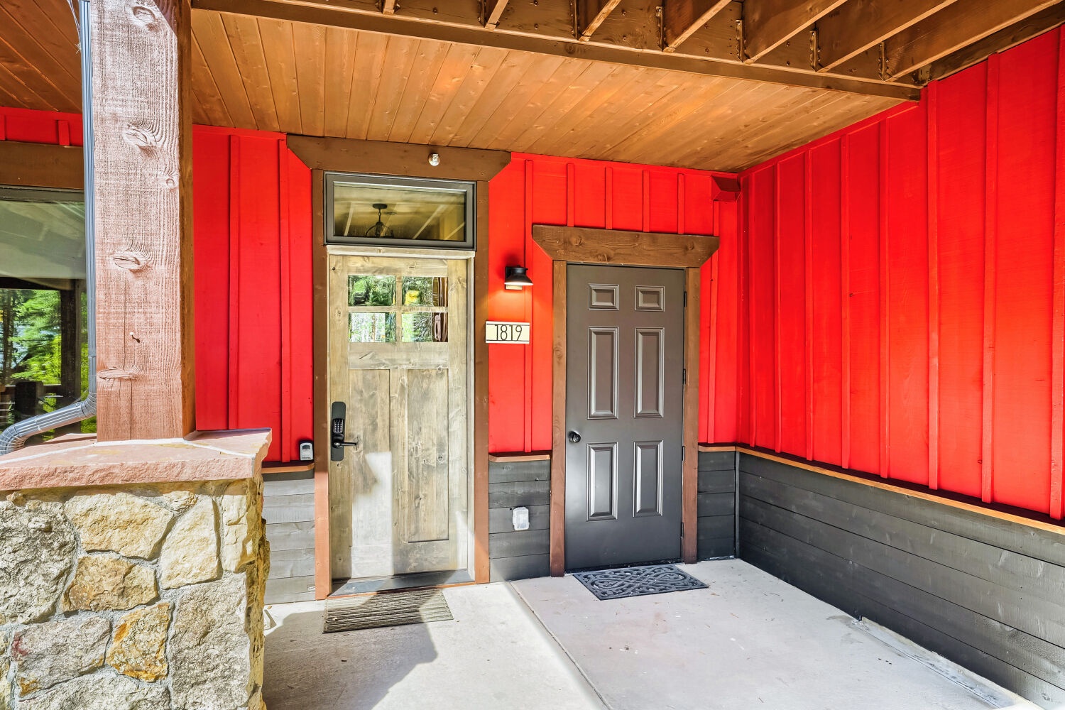 The property exterior features a striking red facade with exposed timber detailing and stone accents. Unit number 1819 marks the entrance to your mountain retreat.