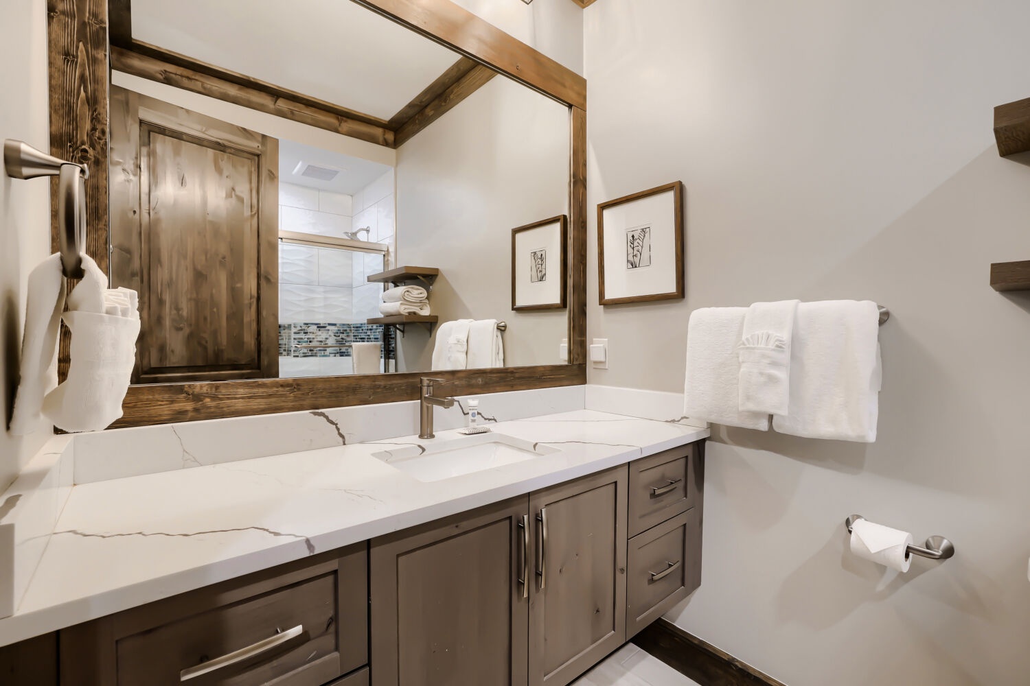 Step into your private spa-like bathroom where rustic wood beams and crisp white marble create a perfect blend of mountain charm and luxury. Fresh towels and thoughtful touches await your arrival.