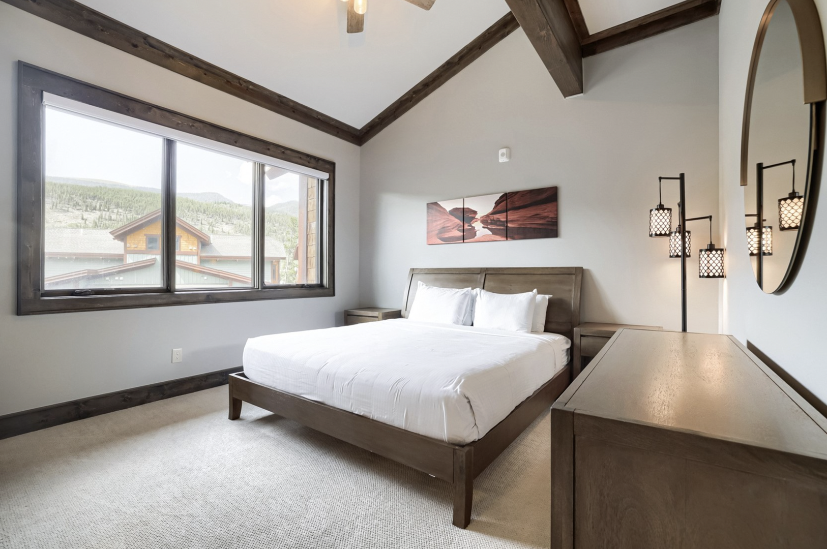 Unwind in this serene bedroom where rustic timber beams meet mountain elegance. Crisp linens invite restful sleep, while warm lighting and rich wood tones create a cozy alpine retreat just for you.