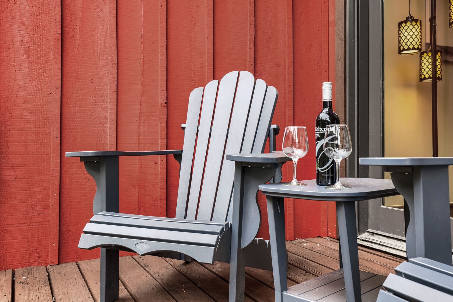 Picture yourself unwinding in your private outdoor nook, where a classic Adirondack chair awaits. Pour a glass of wine, settle in, and let the vibrant red barn backdrop and cozy deck lighting set the mood for your perfect evening escape.