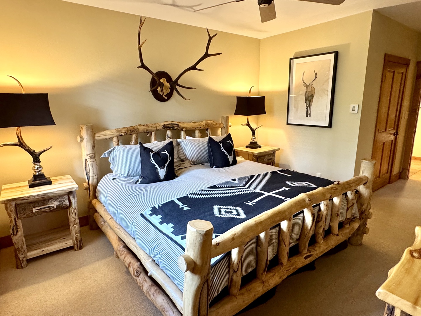Settle into your rustic lodge-style bedroom, where a handcrafted log bed and nature-inspired decor create a cozy mountain retreat perfect for peaceful nights.