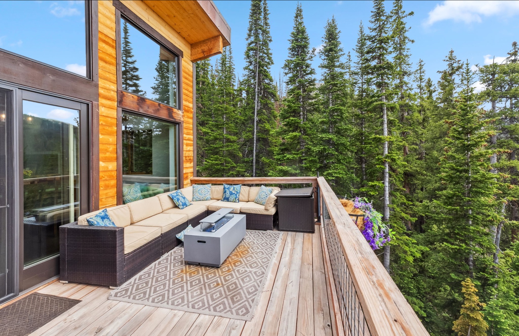 Unwind on your private balcony surrounded by towering pines, where plush seating and fresh mountain air create your perfect outdoor retreat.