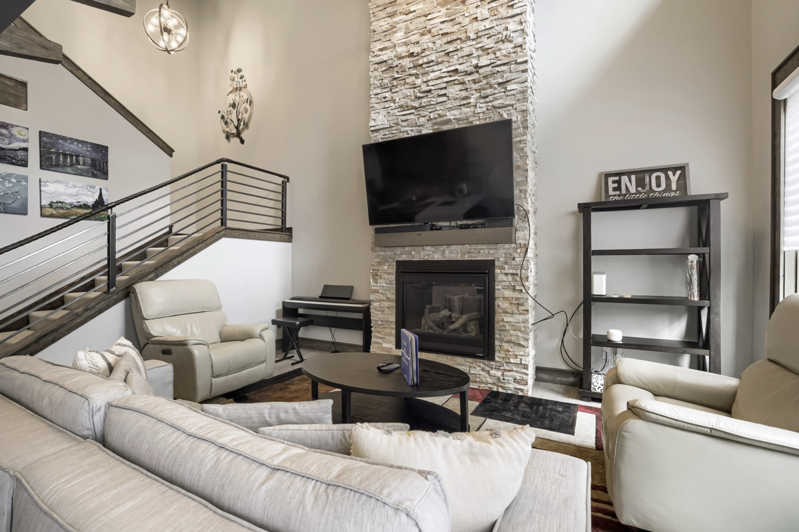 Sink into plush seating by the fireplace's warm glow, where soaring ceilings and modern design create your perfect retreat after a day of adventure.