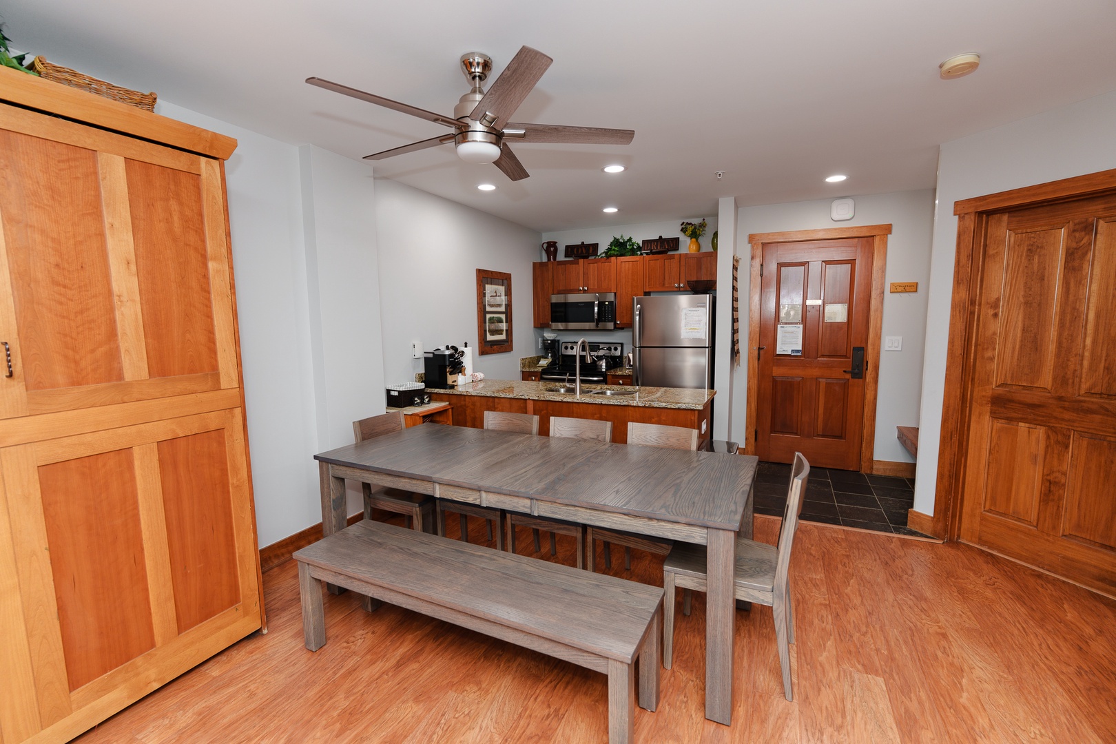 Your open-concept kitchen and dining area features warm wood cabinetry, granite countertops, and a spacious table perfect for gathering with family and friends.