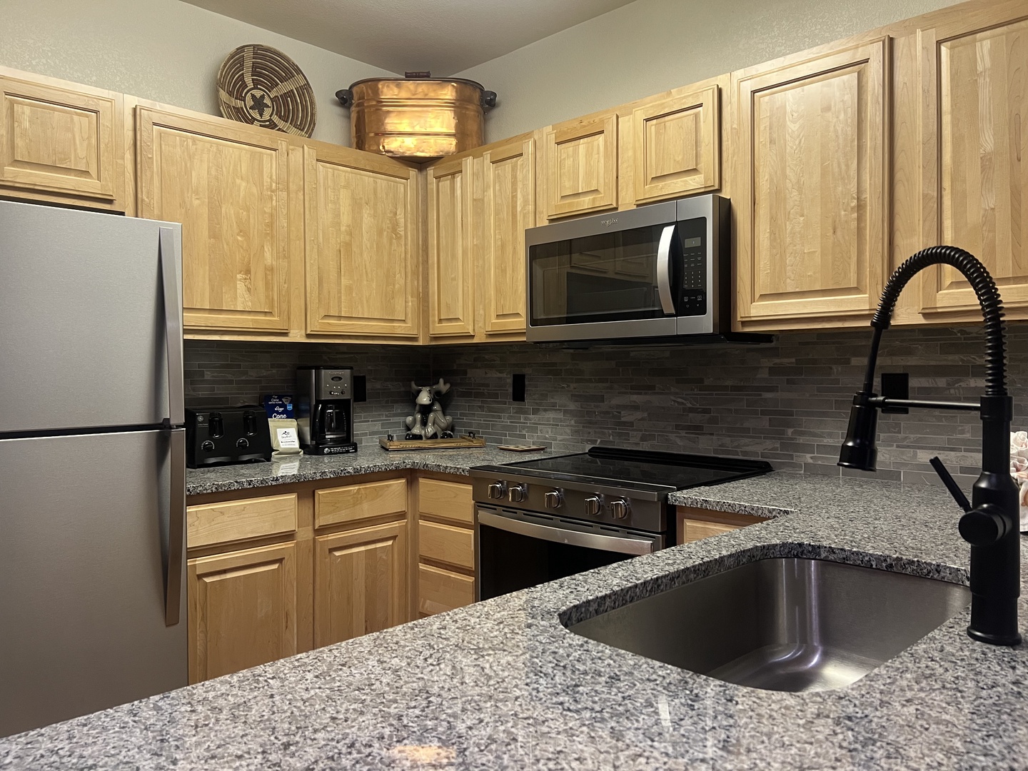 Your kitchen features granite counters, stainless appliances, and all the tools you need to prepare home-cooked meals. Warm wood cabinetry and modern fixtures create a welcoming space for gathering.