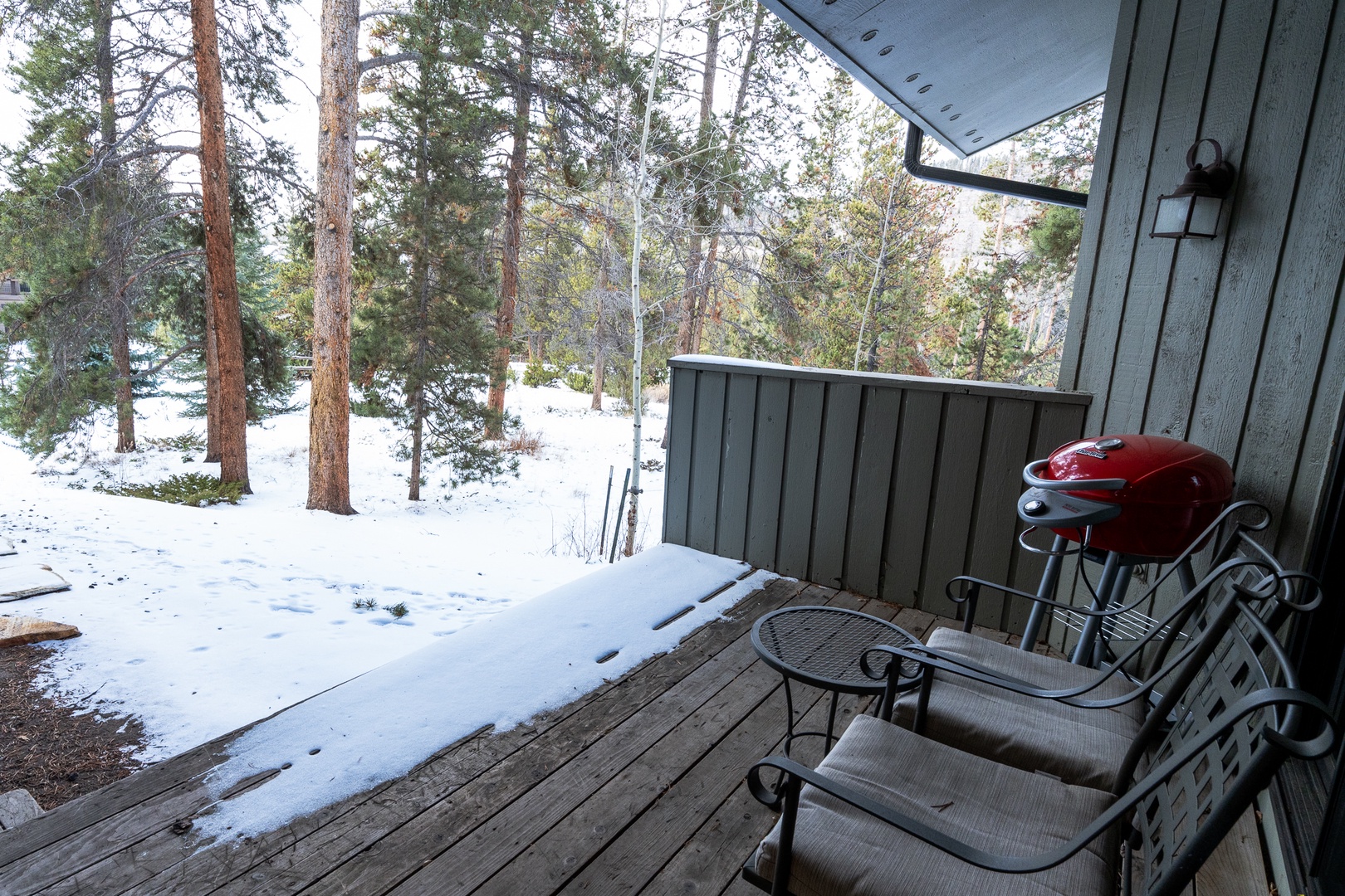 Relax on your private covered deck with comfortable seating while taking in the peaceful winter forest views