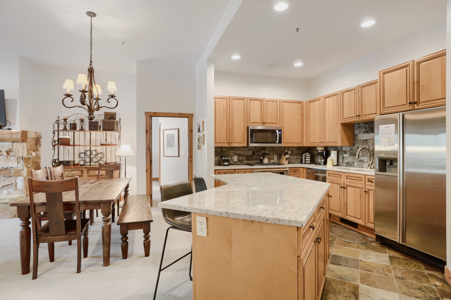 Gather around the spacious island with granite countertops—your hub for morning coffee, meal prep, and impromptu conversations. Stainless steel appliances and warm wood cabinetry create a welcoming space where every meal feels like home.