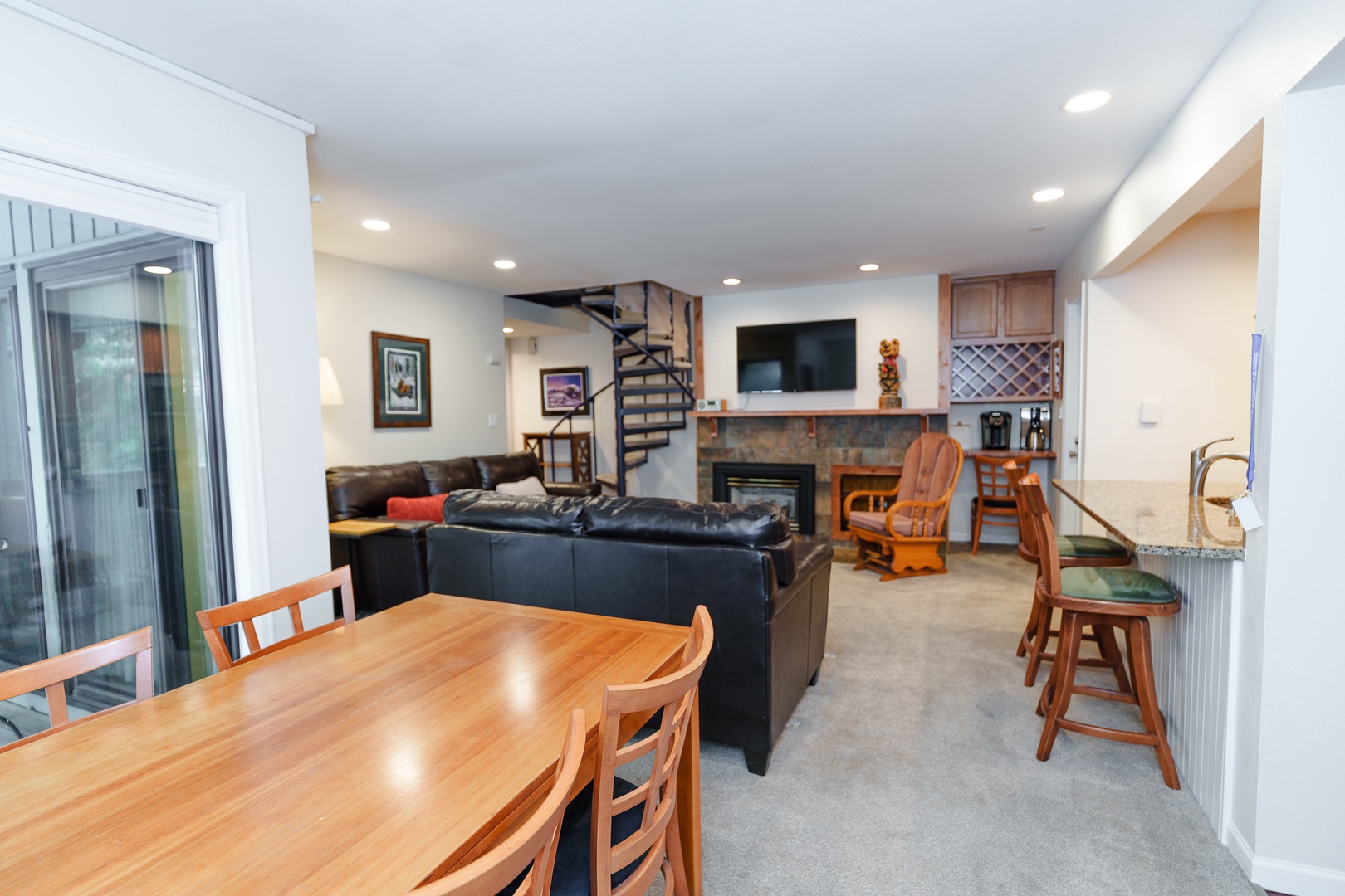 Relax in your spacious open-plan living area featuring comfortable leather seating, a cozy fireplace, and modern entertainment center for memorable evenings together.