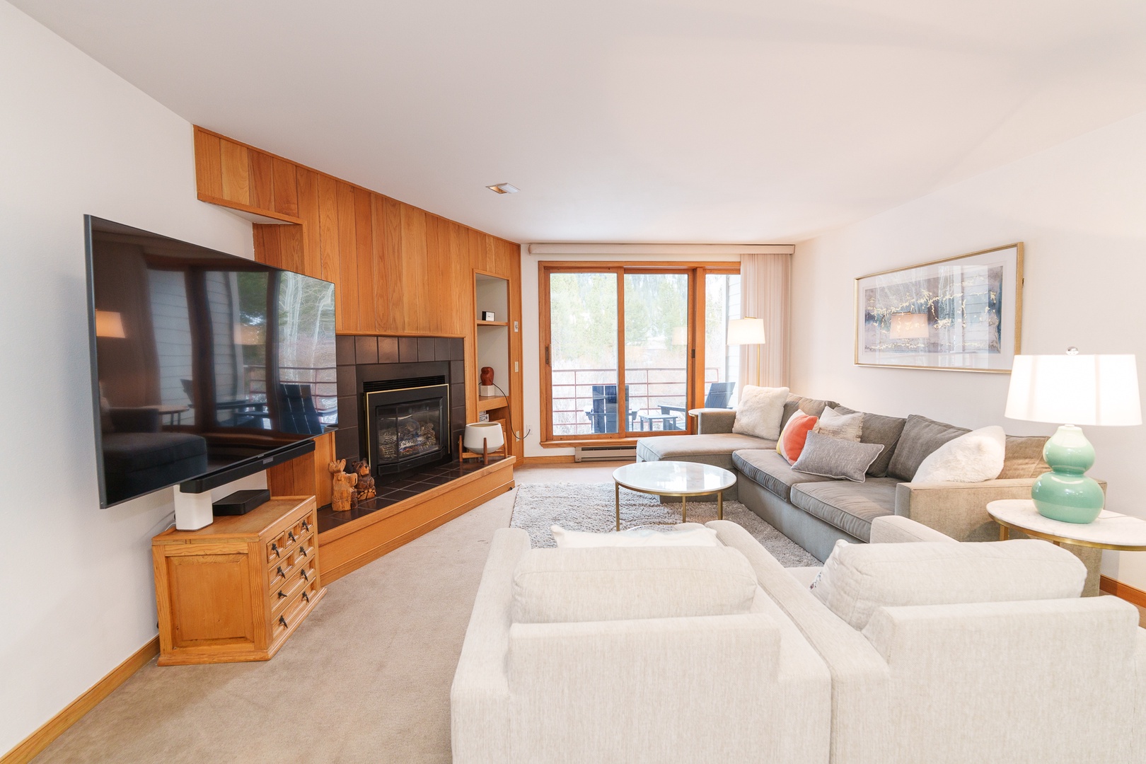 Unwind in your spacious living room featuring a cozy fireplace, large TV, and sectional sofa perfect for relaxing evenings together.