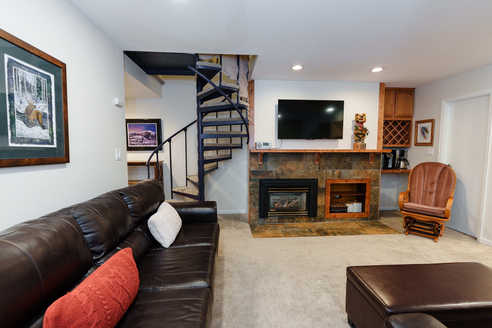 Relax in your spacious living room featuring comfortable leather seating, a cozy fireplace, and entertainment center with flat-screen TV - perfect for unwinding after your adventures.