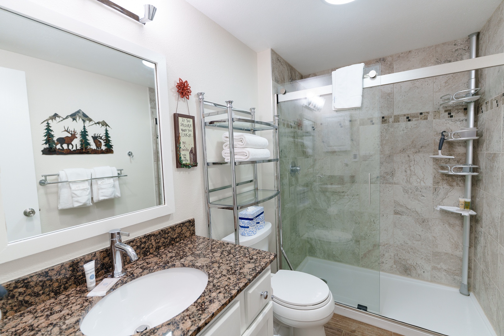 Your private bathroom features granite countertops, a spacious glass-enclosed shower, and thoughtful amenities for a comfortable stay.