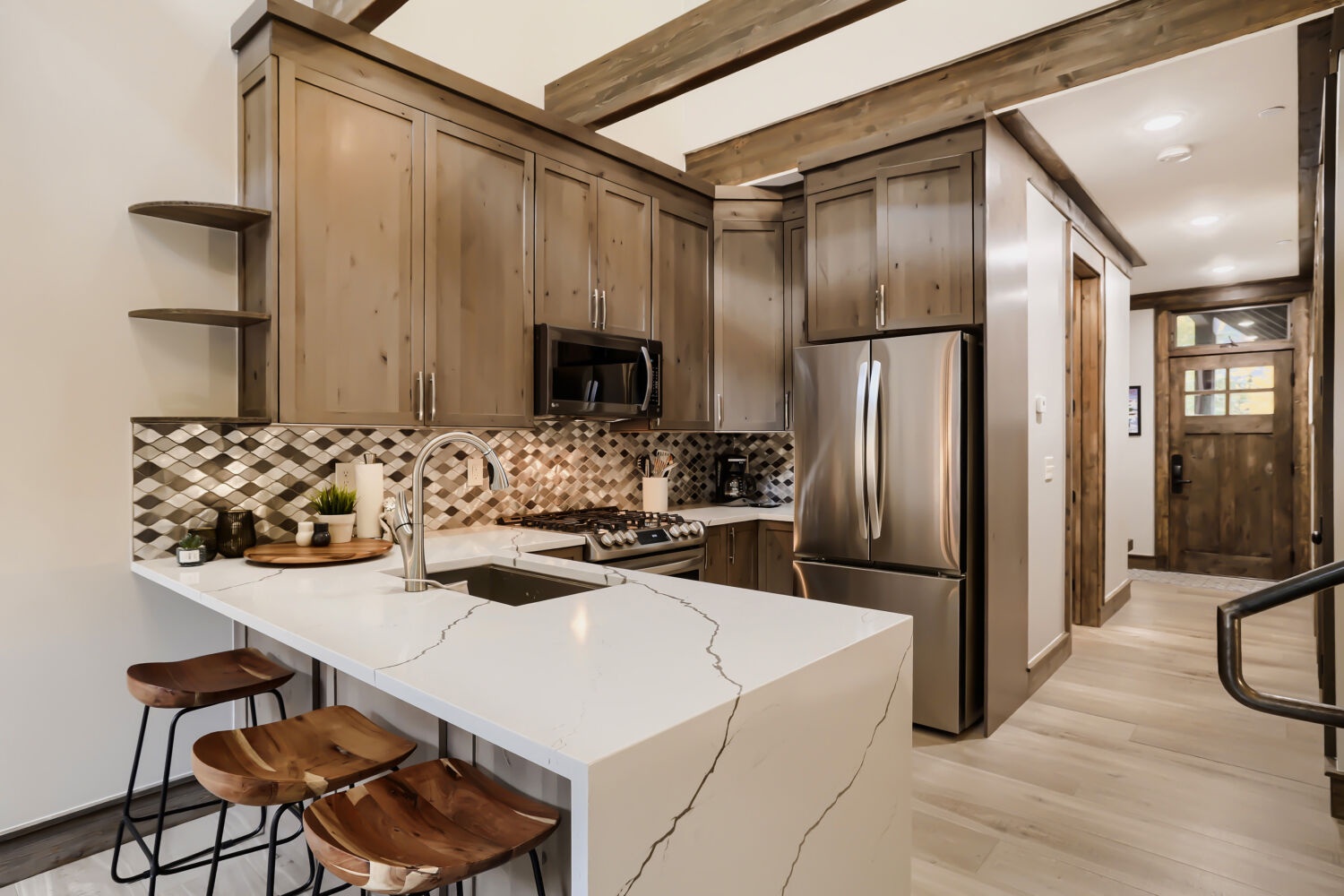 Step into your mountain retreat where rustic wood beams meet modern convenience. Gather around the sleek island, whip up your favorite meals, and feel right at home in this stylish space.