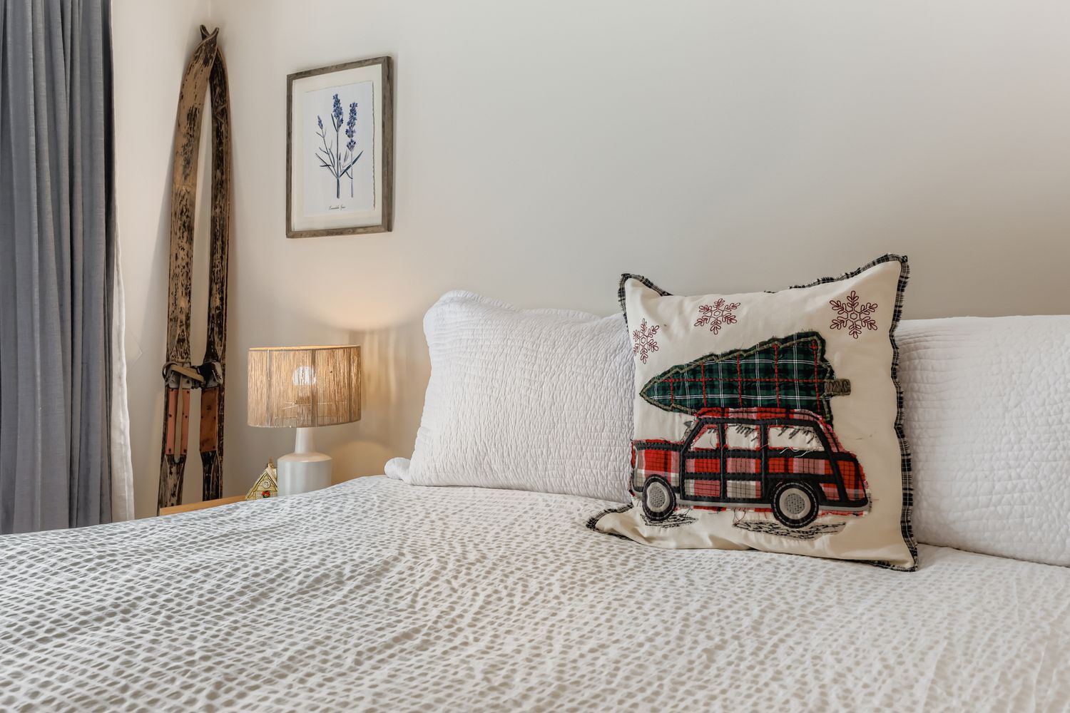 Sink into plush bedding and cozy seasonal pillows in your peaceful bedroom retreat, complete with warm ambient lighting and charming vintage ski décor.