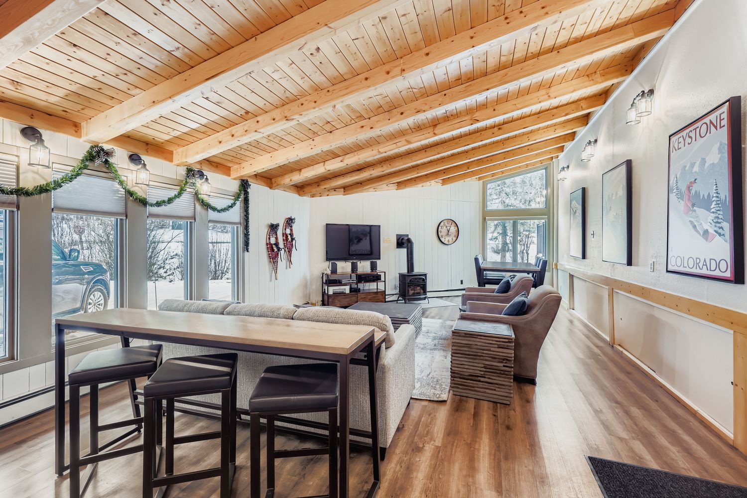 Relax in your spacious guest club house featuring exposed wood beam ceilings, cozy seating, and a warm fireplace - perfect for unwinding after mountain adventures.