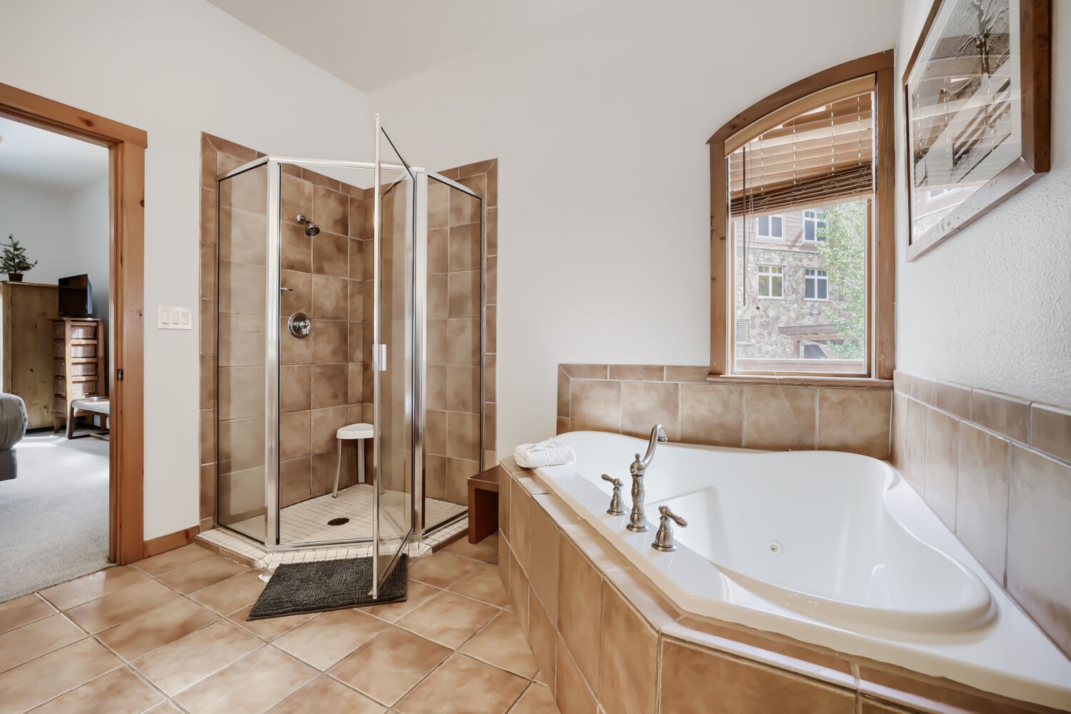 Unwind in your private sanctuary with a luxurious soaking tub and separate glass-enclosed shower, all bathed in natural light from charming arched windows.
