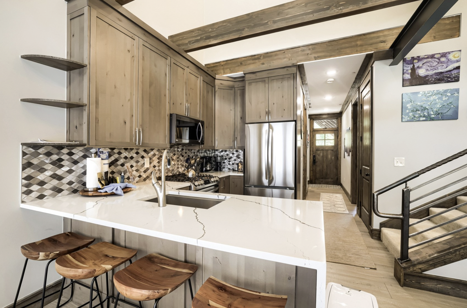 Beautifully designed kitchen with rustic wood beams, marble-topped island, and sleek stainless steel appliances. The perfect blend of natural textures and modern elegance for inspiring meals.