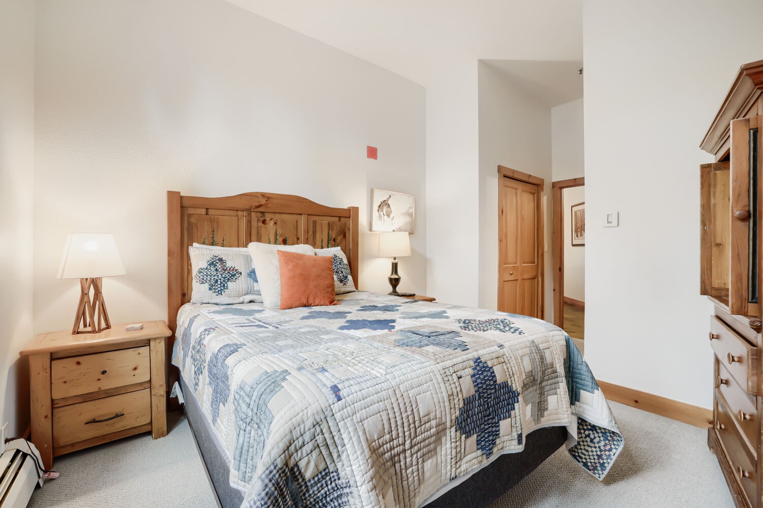 Your peaceful retreat awaits with a handcrafted pine bed dressed in cozy quilts, warm bedside lighting, and charming rustic touches that make this room feel like a true mountain escape.
