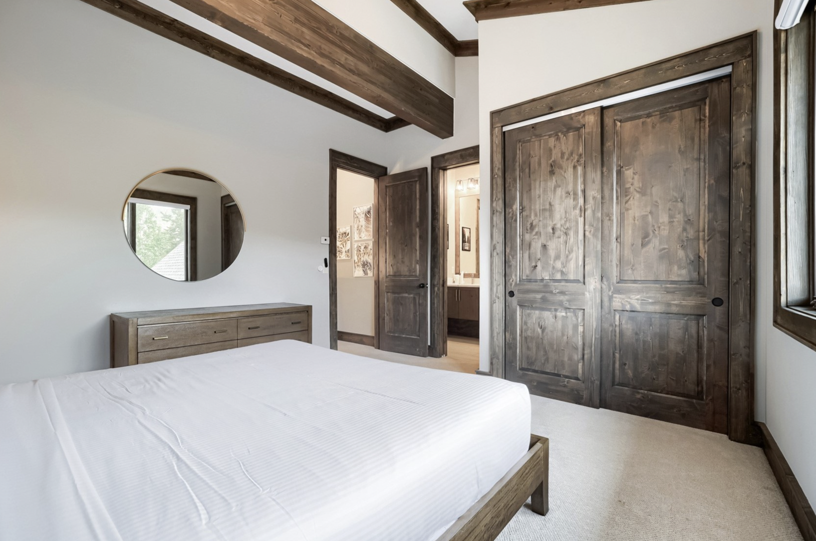 Sink into crisp linens beneath beautiful exposed beams in your bright, restful bedroom. Rustic wood finishes and generous closet space blend warmth with comfort.