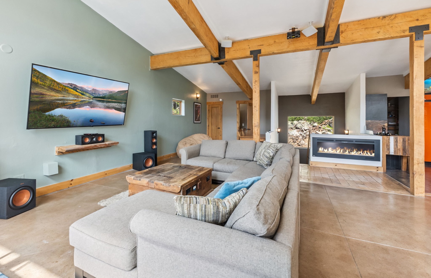 Sink into plush seating beneath soaring timber beams, where your private fireplace glows and a full entertainment system awaits your movie nights.