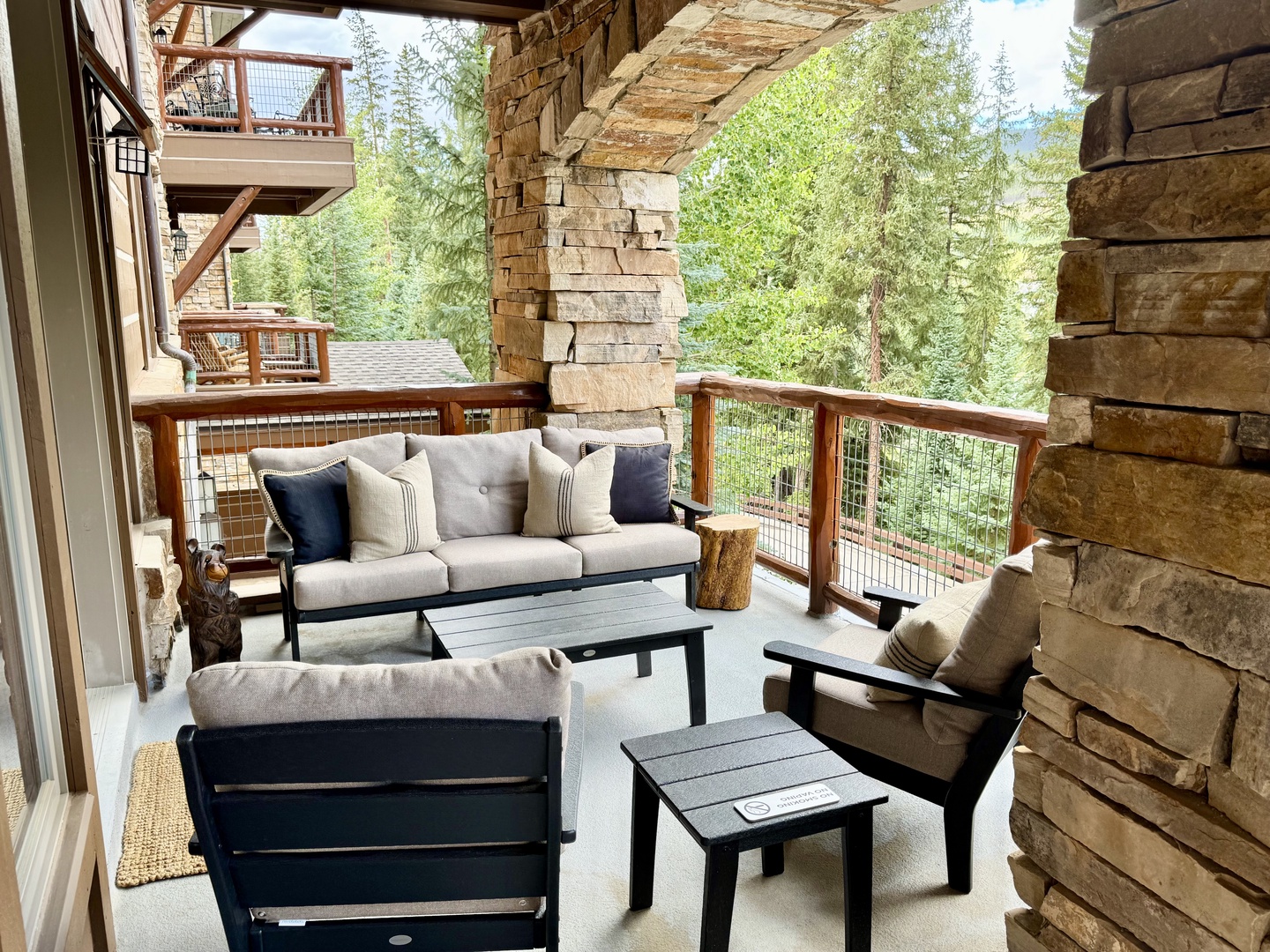 Settle into your private covered terrace with forest views, where cozy seating and mountain air invite you to relax completely.