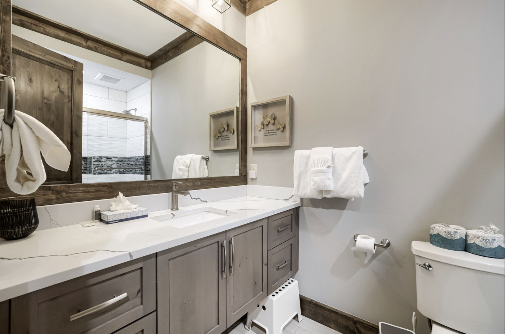 Step into your private retreat, where rustic wood accents meet clean modern design. Freshly folded towels and elegant marble countertops create a peaceful space for you to unwind.