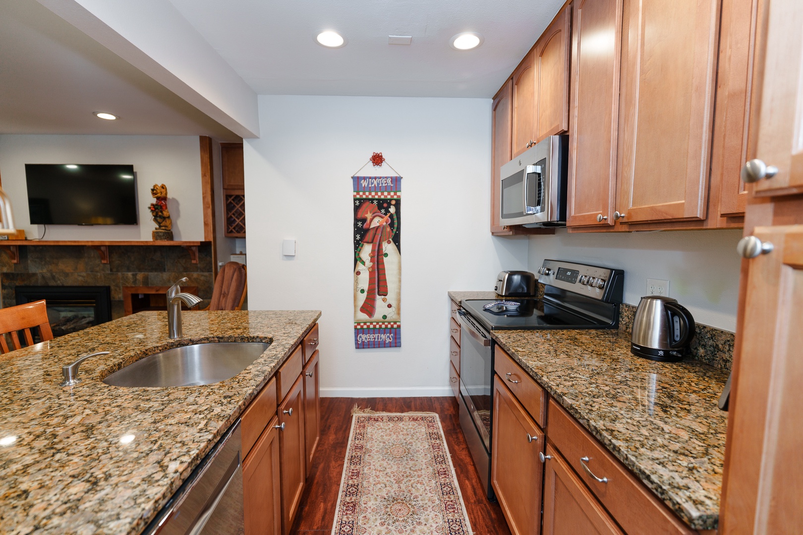 Prepare your favorite meals in this well-appointed kitchen featuring granite countertops, stainless steel appliances, and warm wood cabinetry that creates an inviting cooking space.