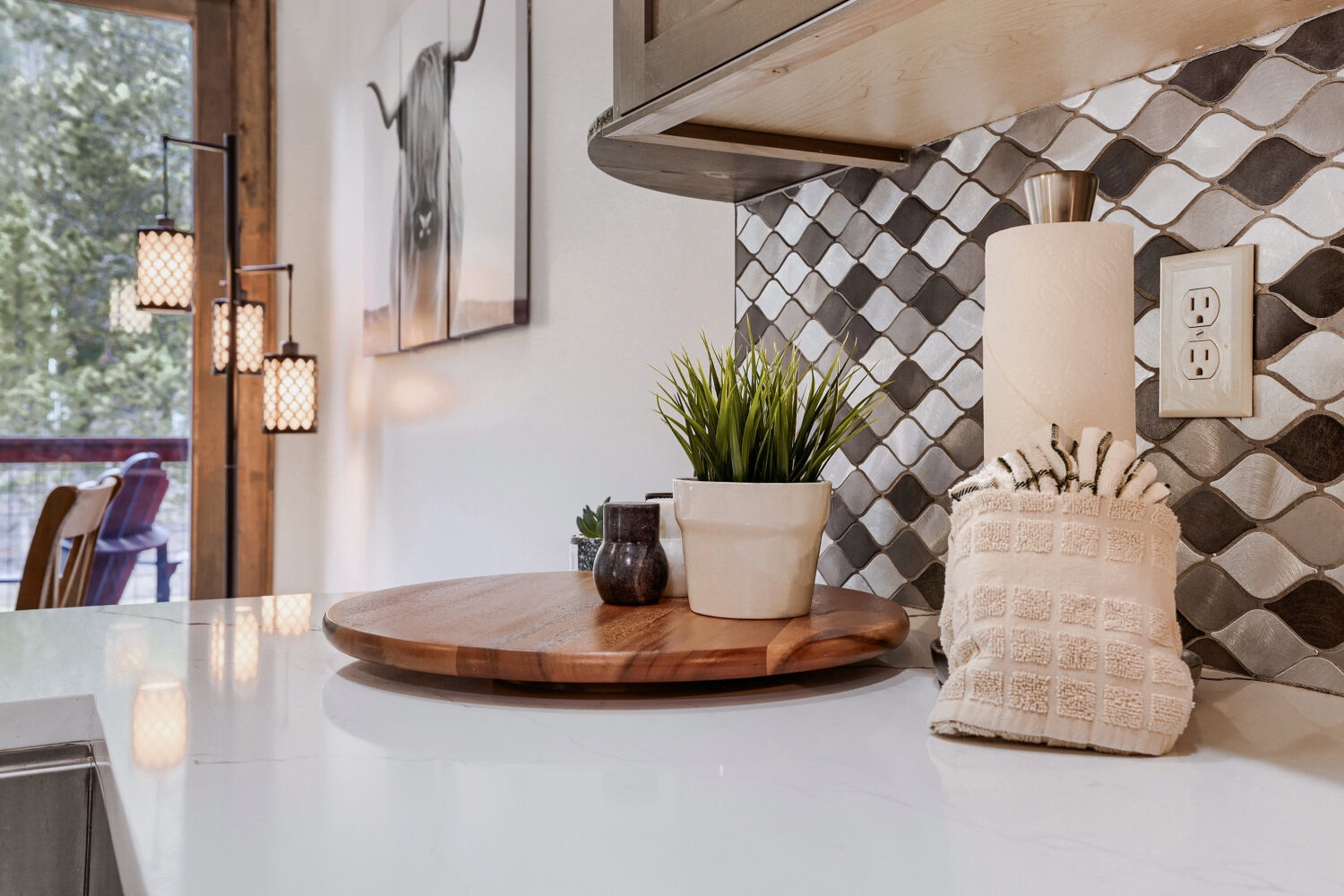 Warm wood tones and modern geometric tile create a welcoming kitchen space where you can enjoy preparing meals together. Natural light filters through nearby windows, adding to the home's relaxed ambiance.