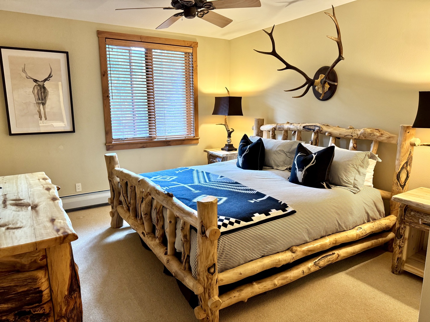 Sink into rustic luxury with this handcrafted log bed, perfectly complemented by cozy throws and mountain-inspired decor. Your restful mountain retreat awaits with warm lighting and authentic charm.