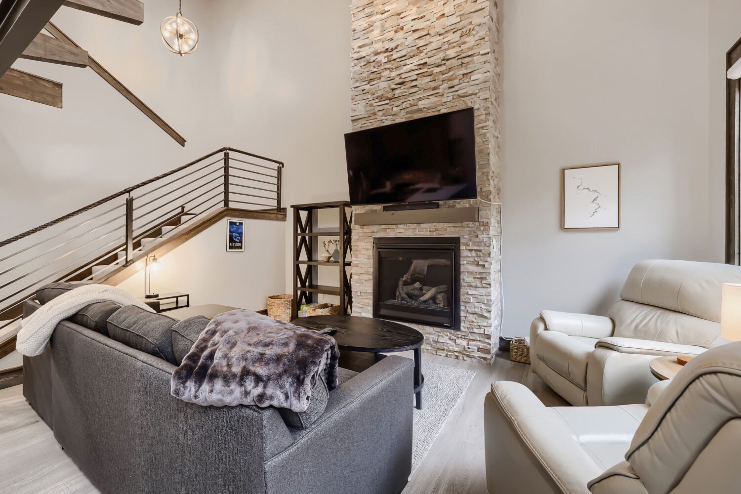 Sink into plush seating by your own stone fireplace, where soaring ceilings and modern mountain design create an inviting retreat after your adventures.