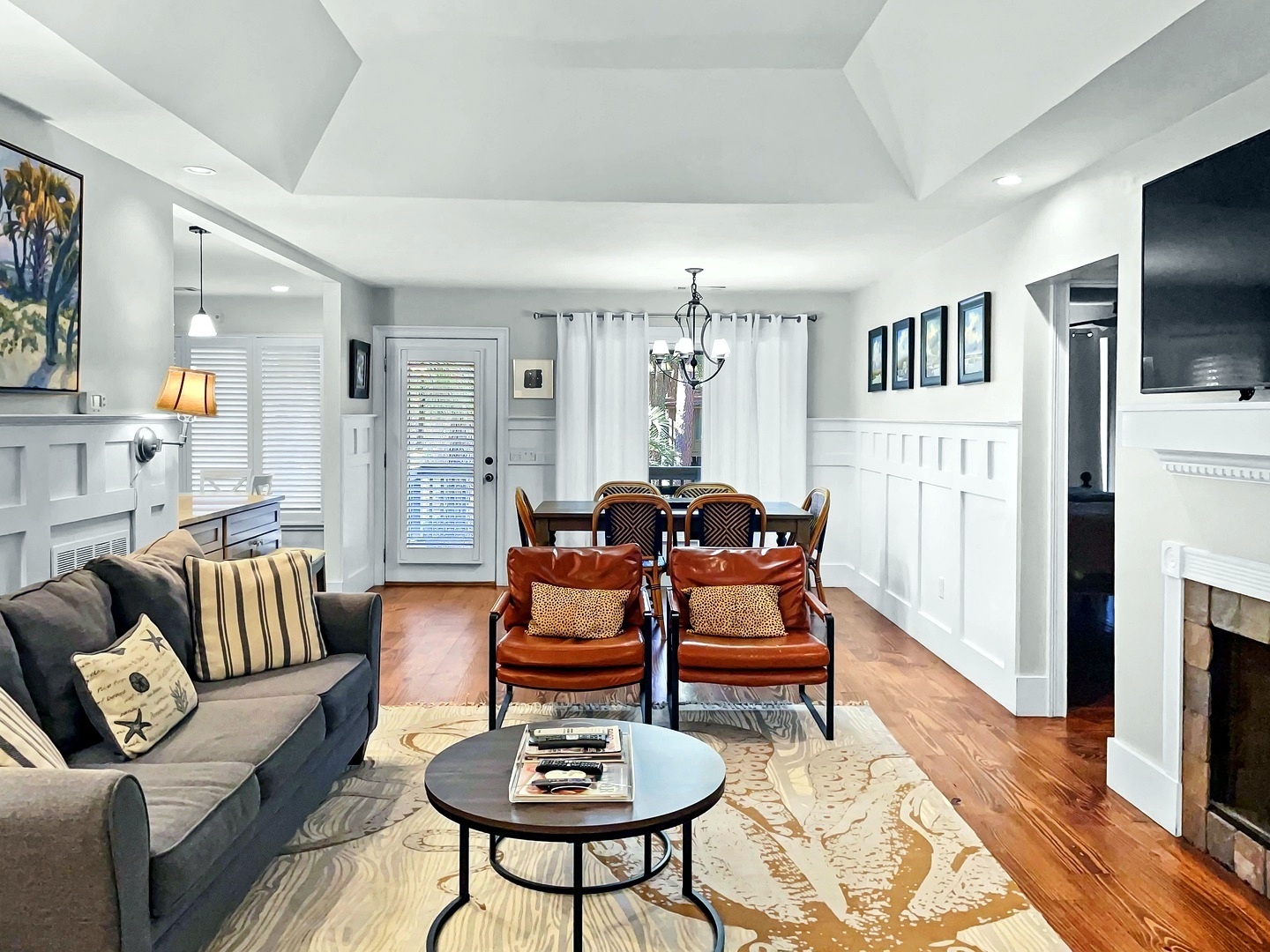 Settle into your stylish living space where cozy gray sofas and warm leather chairs create the perfect spot for relaxation.