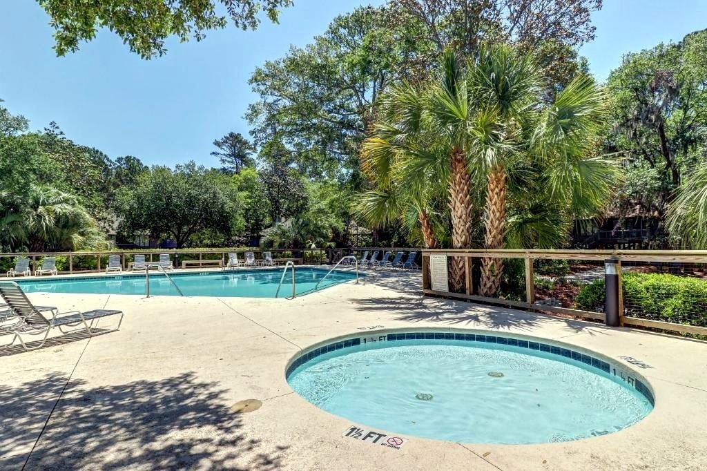 Sparkling resort-style pool and hot tub surrounded by lush palms where you can soak up the sun or unwind after exploring.