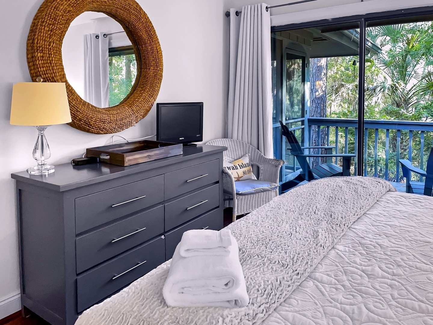 Wake up in your cozy bedroom with tropical garden views through sliding doors, complete with TV and reading chair.
