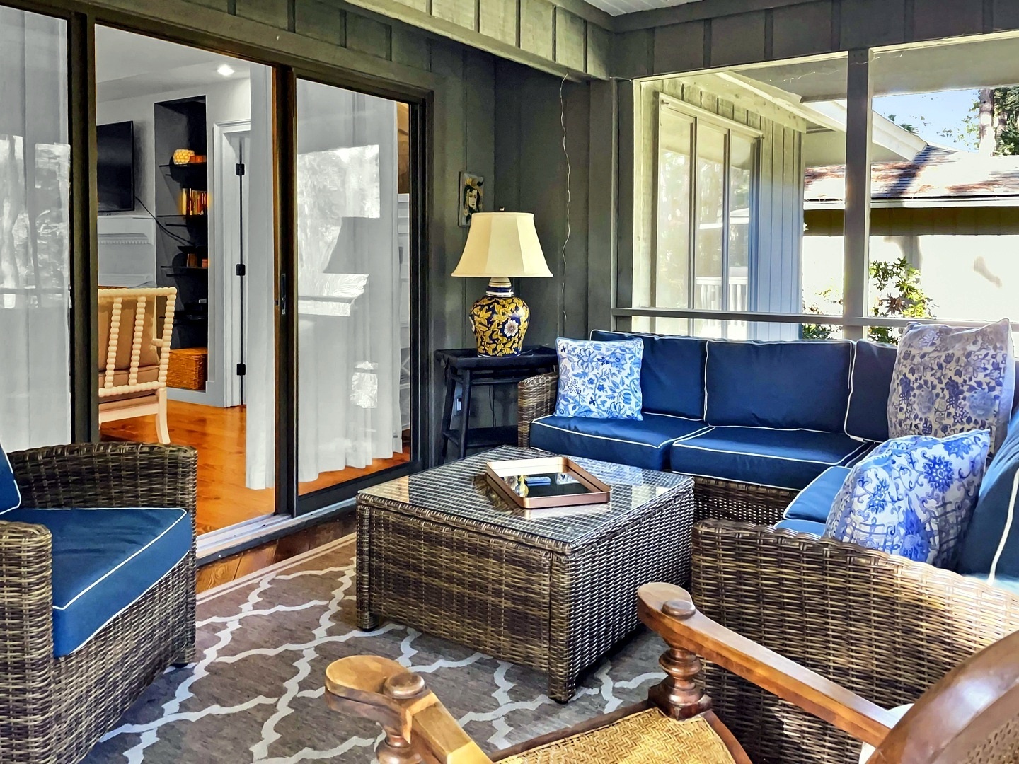 Unwind in your private screened porch with plush navy seating, perfect for morning coffee or evening relaxation while staying connected to indoor comfort.