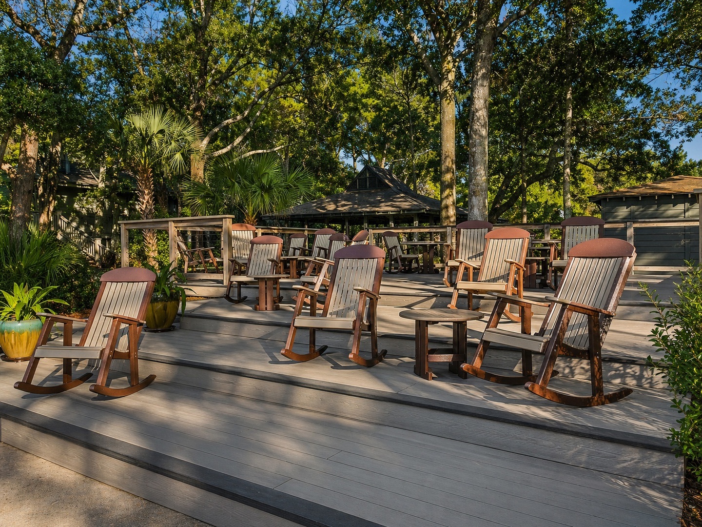 Relax in your own wooden rocking chairs on this spacious deck, surrounded by lush trees and tropical palms for peaceful moments.