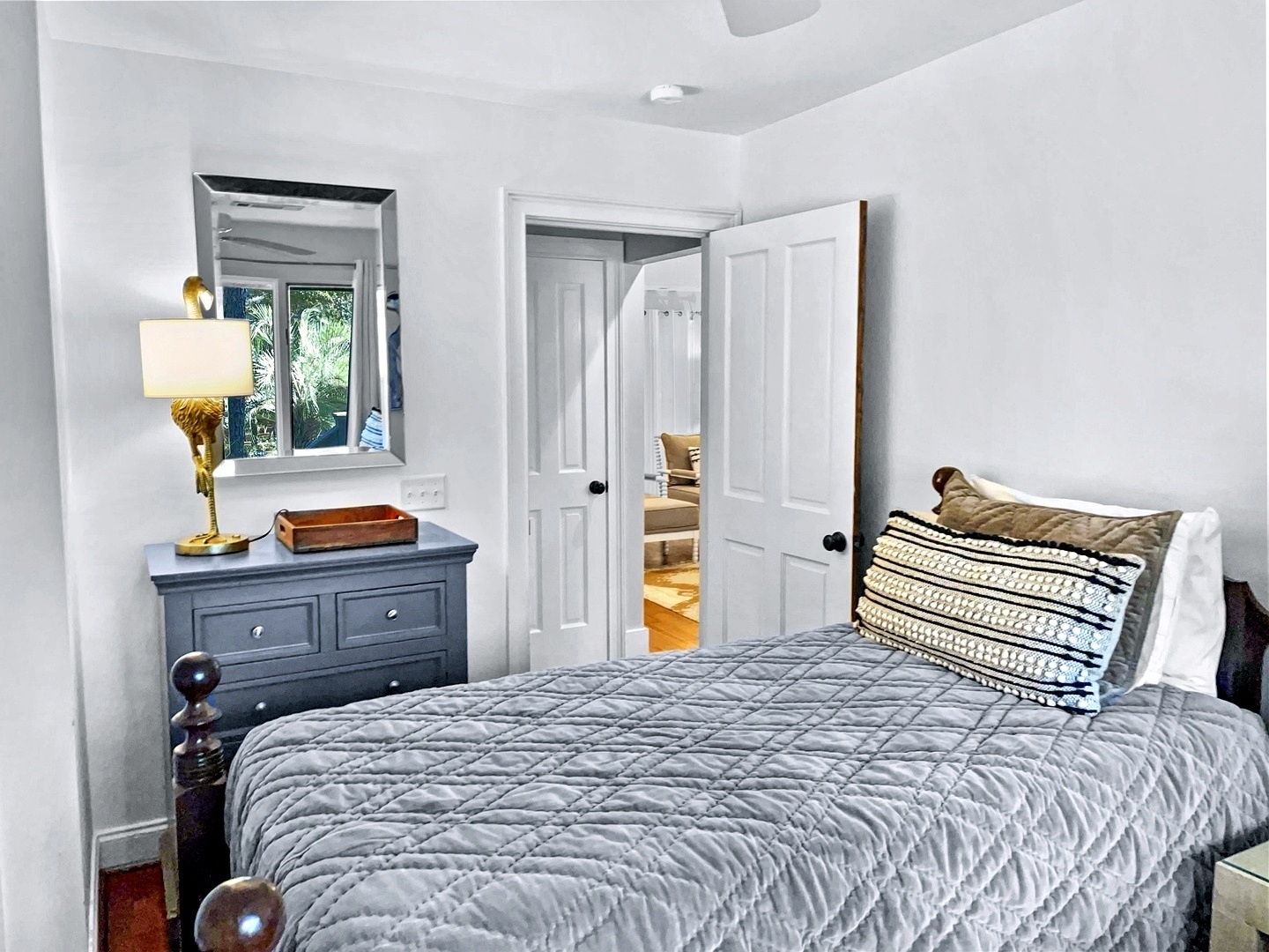 Drift into peaceful slumber in this cozy bedroom where soft gray linens and warm lighting create your perfect nighttime retreat.