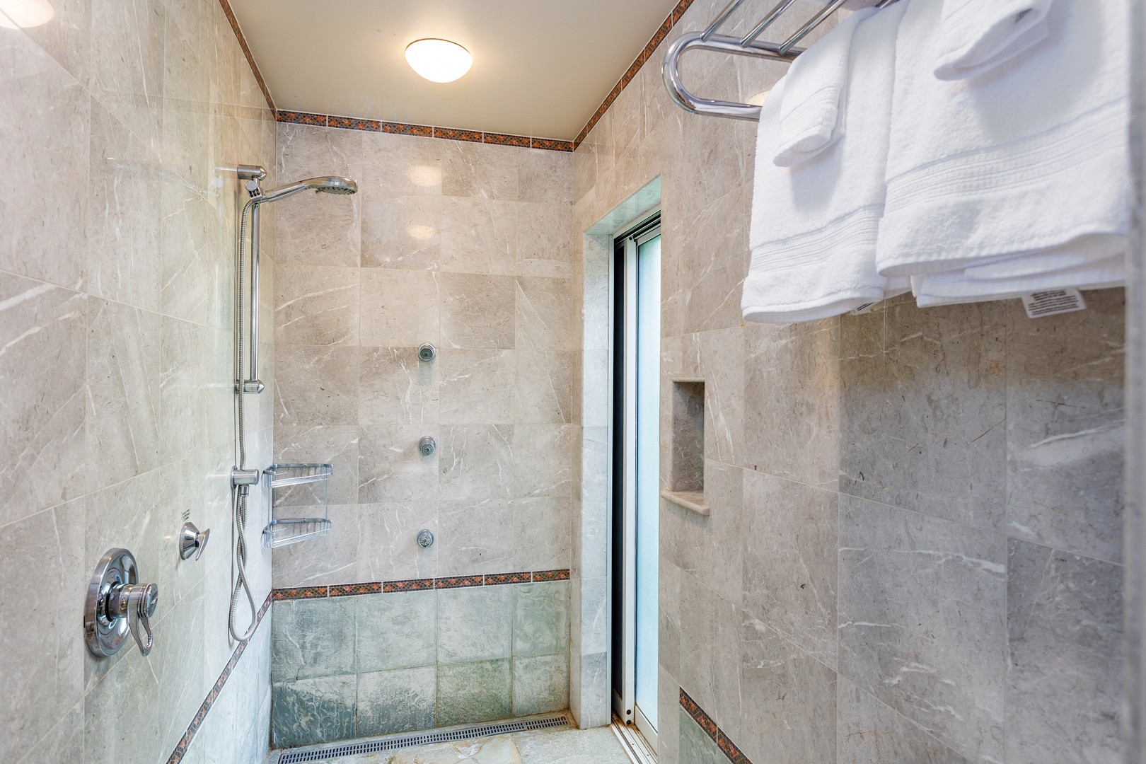 Primary Bathroom - Step into your private spa-like retreat with elegant tile work, a rainfall showerhead, and plush towels waiting for you. The built-in niche keeps your essentials close at hand.