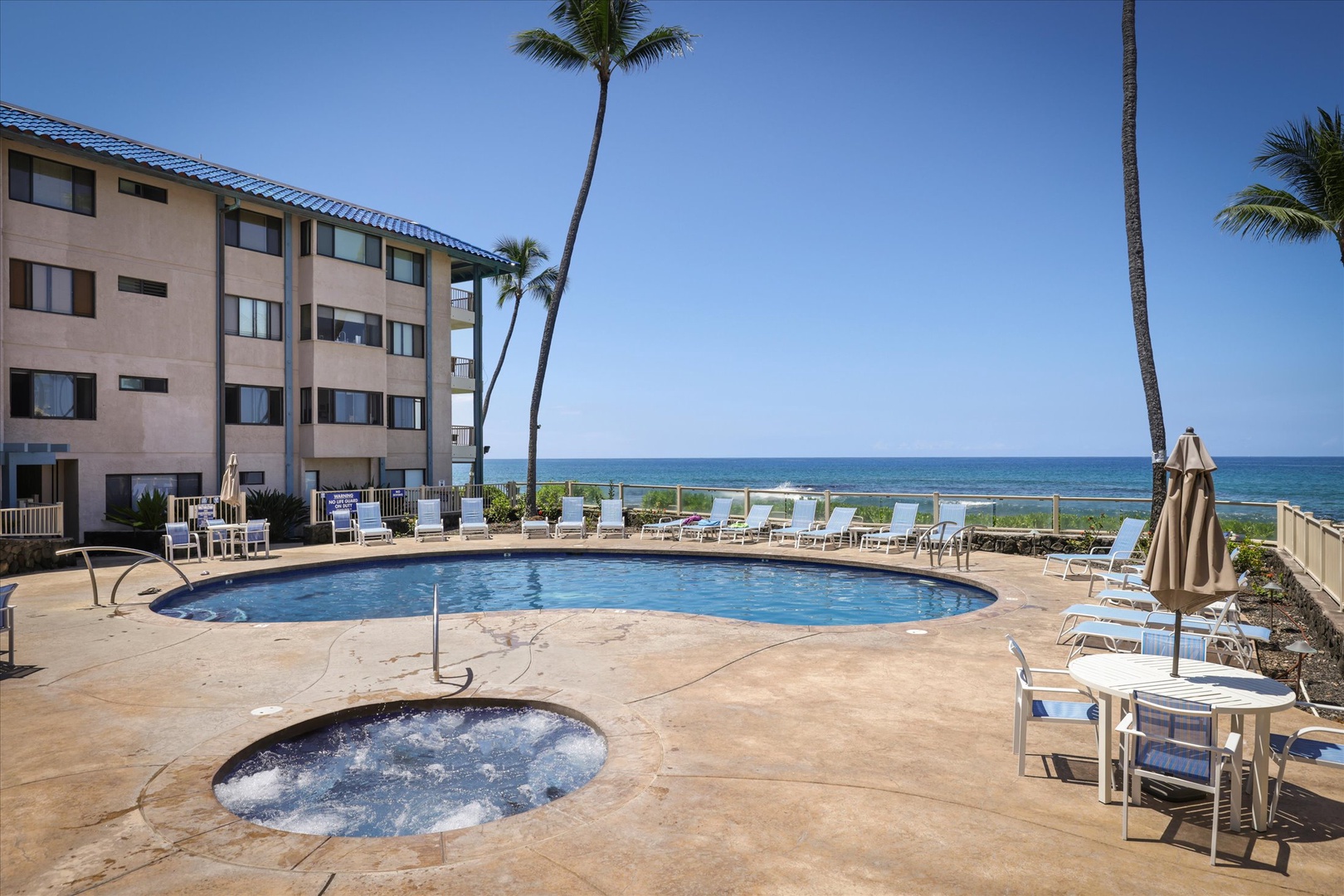 The beachfront pool deck frames stunning ocean horizons under swaying palms. Lounge by the water, soak in the hot tub, or simply unwind with the sound of waves nearby.