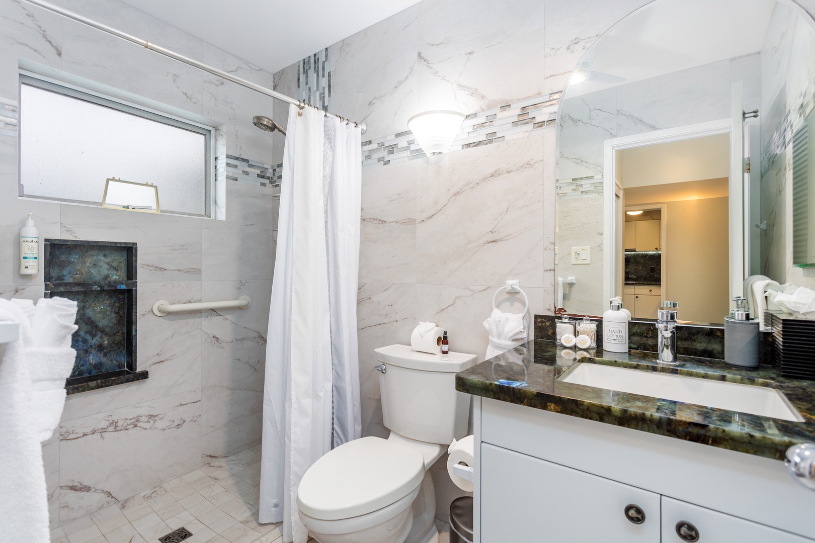 Your private bathroom features elegant marble-look tile, a spacious walk-in shower, and a granite vanity—comfort and style for your stay.