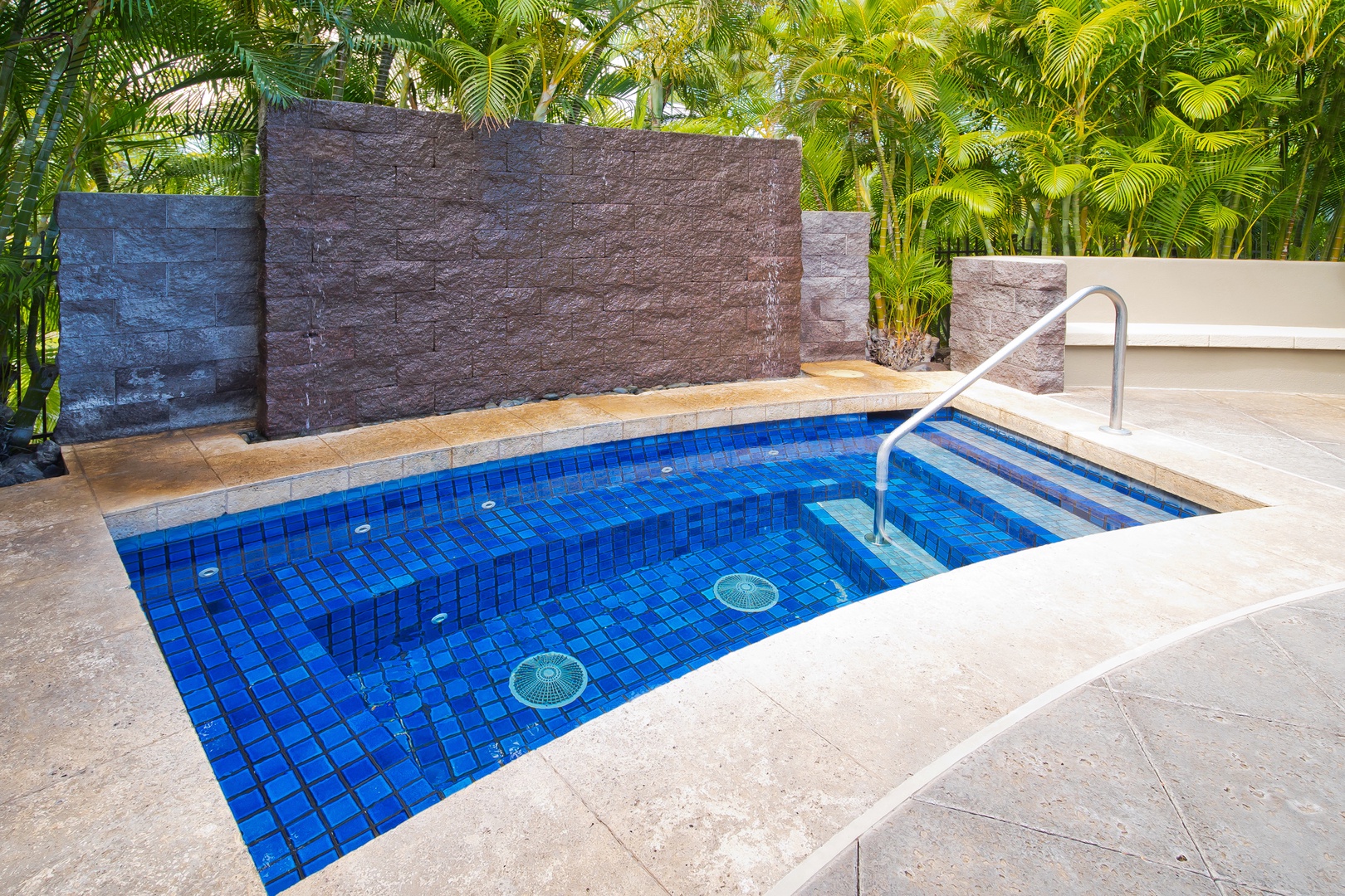 Your private pool awaits, framed by lush tropical palms and modern stone walls—perfect for cooling off under the warm sun or unwinding in complete serenity.