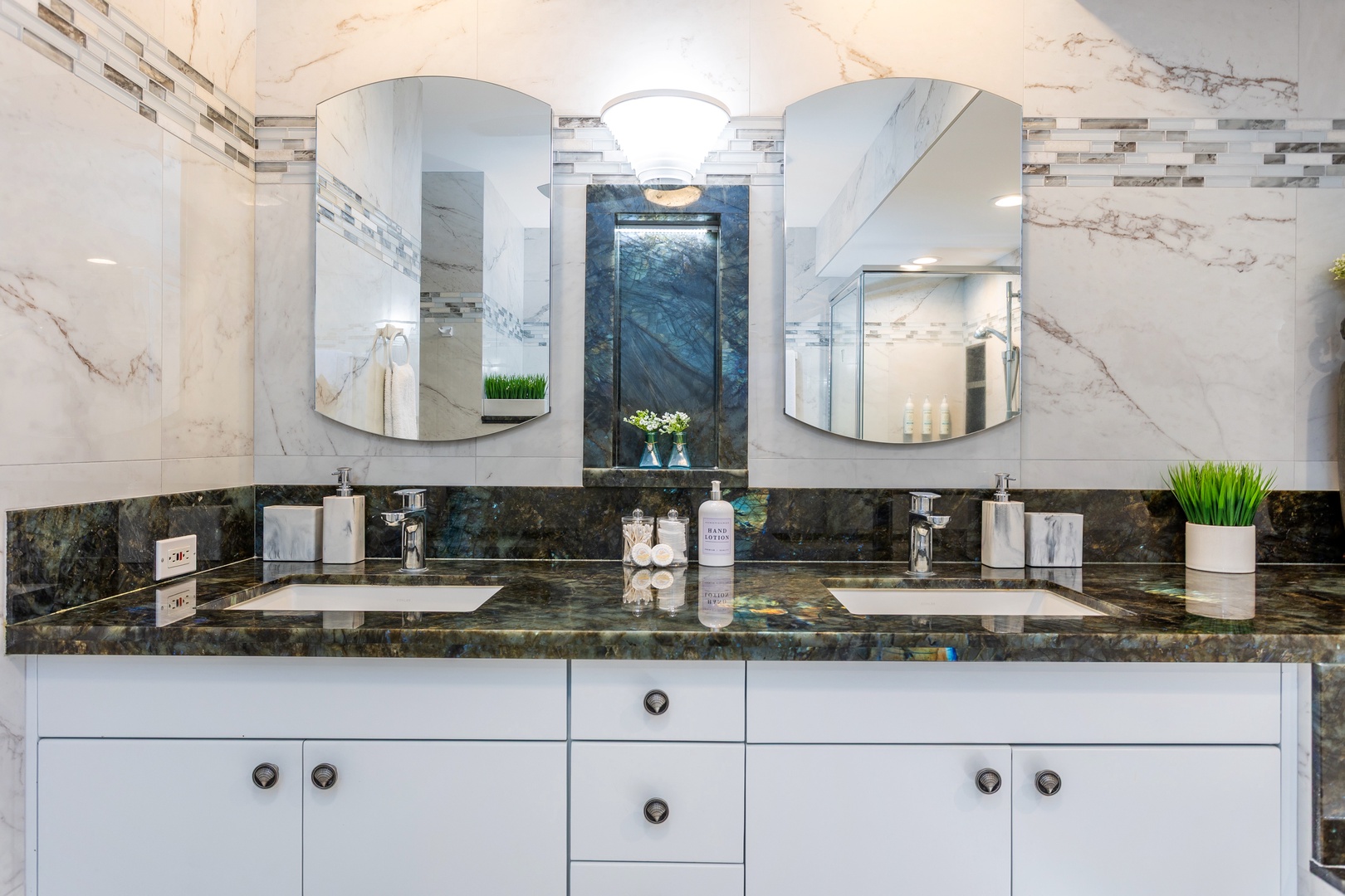 Indulge in the spa-like ambiance with dual vanities, sleek marble accents, and modern fixtures—your personal retreat to refresh and unwind.