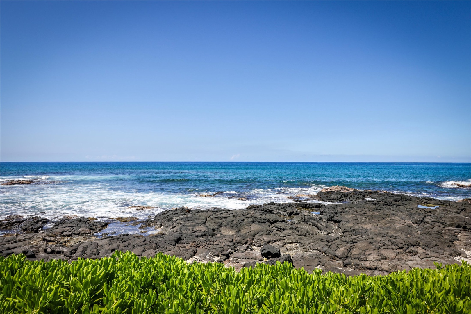 Stunning coastal setting with rocky shoreline and vibrant ocean views, offering a serene backdrop to the property.