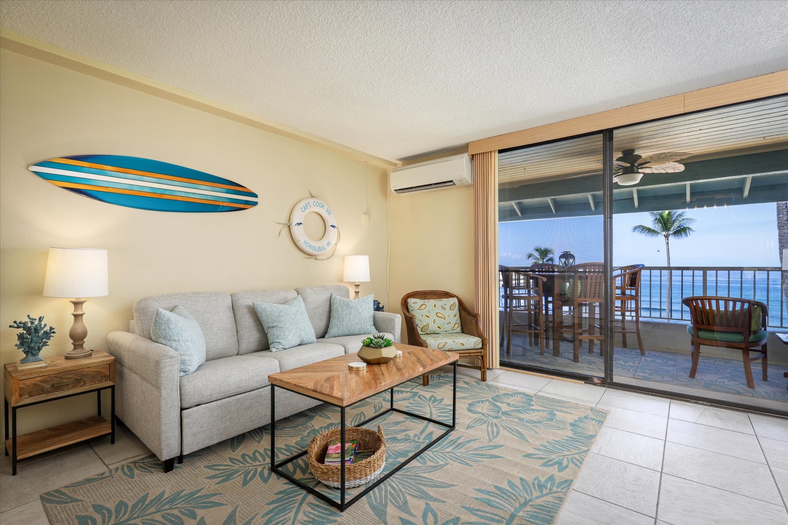 Your beachside retreat blends island charm with comfort—unwind on the cozy sofa, step onto your private lanai with ocean breezes, and soak in sweeping sea views framed by swaying palms.