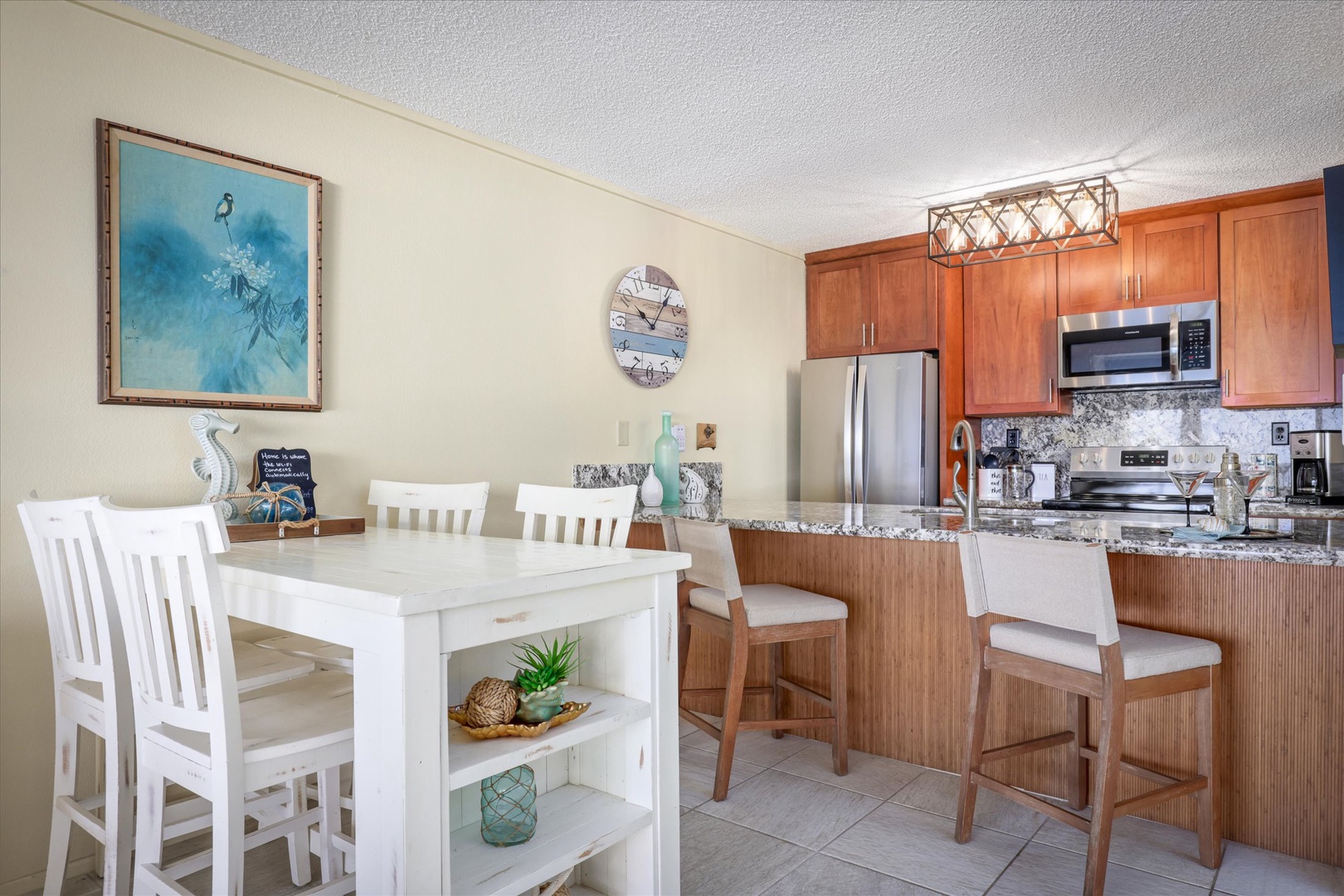 Gather around the cozy dining table or belly up to the breakfast bar, where morning coffee and sunset views blend seamlessly in this bright, coastal-inspired kitchen space.