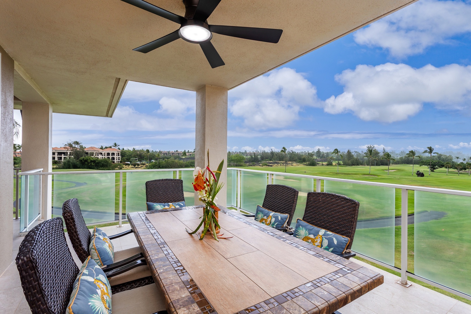 Your private terrace overlooks lush fairways and tranquil water features, perfect for alfresco dining under the cooling fan with tropical breezes and endless blue skies above.