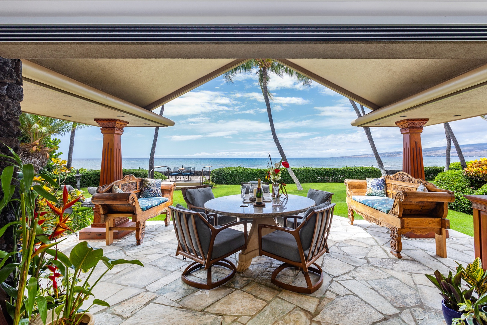 Lanai - Imagine your morning coffee or evening cocktail here—elegant tropical lanai with ocean views framed by swaying palms, plush seating inviting you to linger, and the sound of waves nearby.